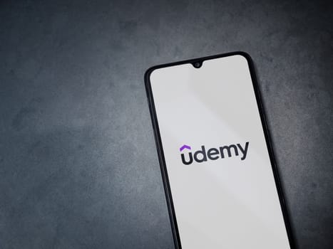Lod, Israel - July 16,2023: Udemy app launch screen on smartphone on dark marble stone background. Top view flat lay with copy space.