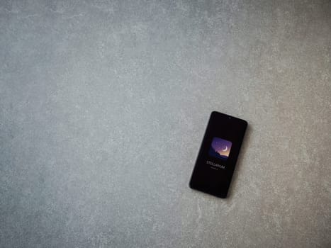 Lod, Israel - July 16,2023: Stellarium - Star Map app launch screen on smartphone on ceramic stone background. Top view flat lay with copy space.