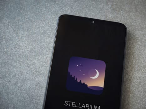 Lod, Israel - July 16,2023: Stellarium - Star Map app launch screen on smartphone on ceramic stone background. Top view flat lay with copy space.