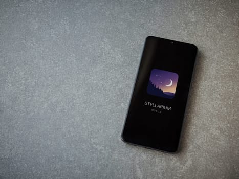 Lod, Israel - July 16,2023: Stellarium - Star Map app launch screen on smartphone on ceramic stone background. Top view flat lay with copy space.