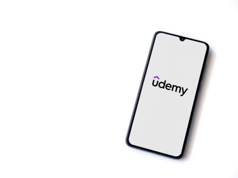 Lod, Israel - July 16,2023: Udemy app launch screen on smartphone on white background. Top view flat lay with copy space.