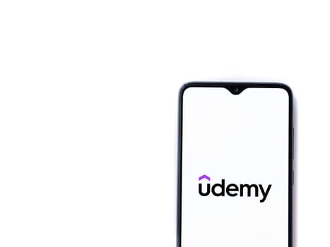Lod, Israel - July 16,2023: Udemy app launch screen on smartphone on white background. Top view flat lay with copy space.