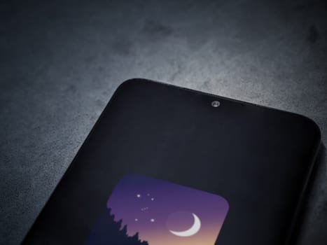 Lod, Israel - July 16,2023: Stellarium - Star Map app launch screen on smartphone on dark marble stone background. Top view flat lay with copy space.