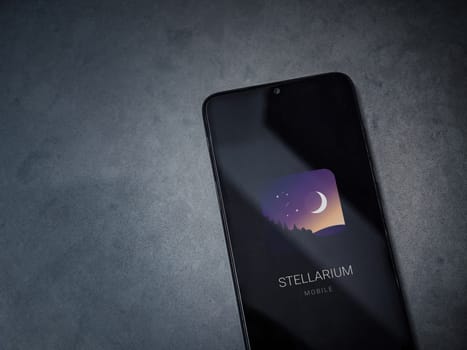Lod, Israel - July 16,2023: Stellarium - Star Map app launch screen on smartphone on dark marble stone background. Top view flat lay with copy space.