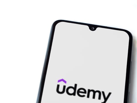 Lod, Israel - July 16,2023: Udemy app launch screen on smartphone on white background. Top view flat lay with copy space.