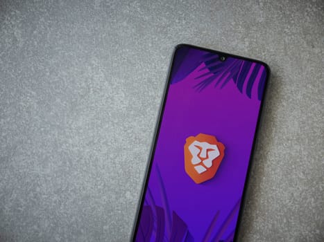 Lod, Israel - July 16,2023: Brave Private Browser app launch screen on smartphone on ceramic stone background. Top view flat lay with copy space.