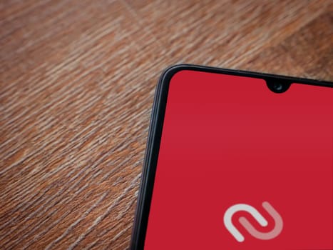 Lod, Israel - July 16,2023: Twilio Authy Authenticator app launch screen on smartphone on wooden background. Top view flat lay with copy space.