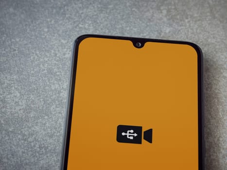 Lod, Israel - July 16,2023: USB Camera app launch screen on smartphone on ceramic stone background. Top view flat lay with copy space.