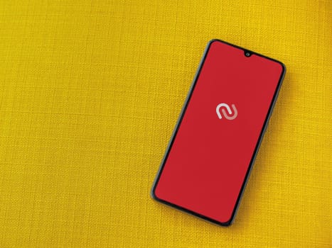 Lod, Israel - July 16,2023: Twilio Authy Authenticator app launch screen on smartphone on yellow fabric background. Top view flat lay with copy space.