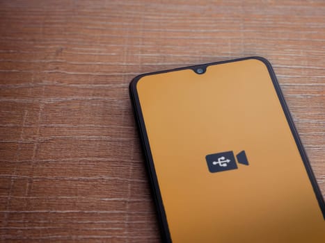 Lod, Israel - July 16,2023: USB Camera app launch screen on smartphone on wooden background. Top view flat lay with copy space.