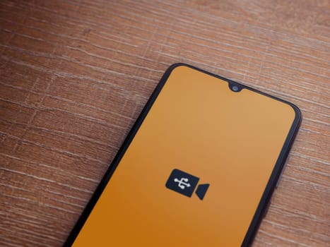 Lod, Israel - July 16,2023: USB Camera app launch screen on smartphone on wooden background. Top view flat lay with copy space.