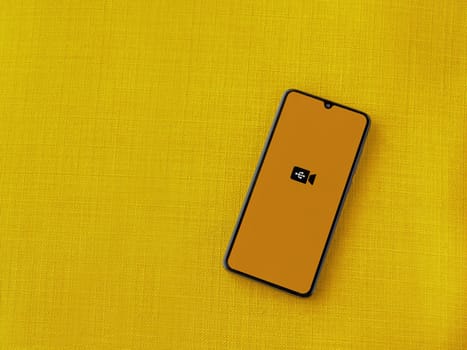 Lod, Israel - July 16,2023: USB Camera app launch screen on smartphone on yellow fabric background. Top view flat lay with copy space.
