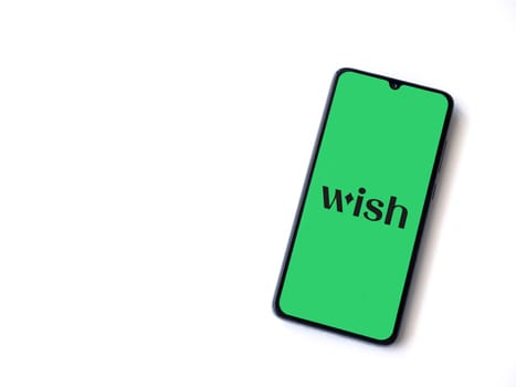 Lod, Israel - July 16,2023: Wish app launch screen on smartphone on white background. Top view flat lay with copy space.