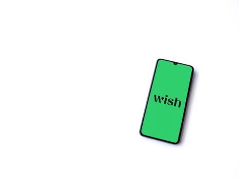 Lod, Israel - July 16,2023: Wish app launch screen on smartphone on white background. Top view flat lay with copy space.