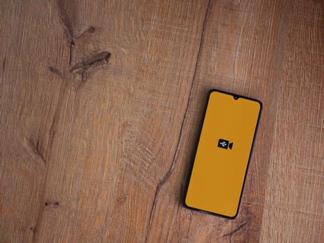 Lod, Israel - July 16,2023: USB Camera app launch screen on smartphone on wooden background. Top view flat lay with copy space.