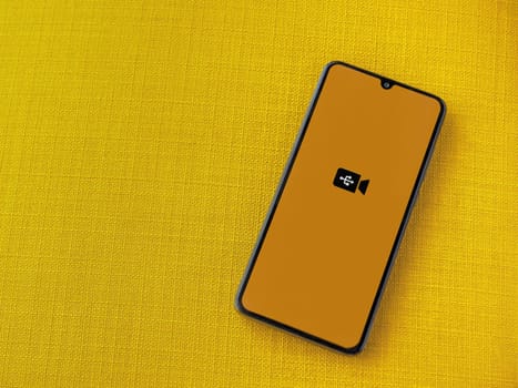 Lod, Israel - July 16,2023: USB Camera app launch screen on smartphone on yellow fabric background. Top view flat lay with copy space.