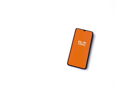 Lod, Israel - July 16,2023: Temu app launch screen on smartphone on white background. Top view flat lay with copy space.