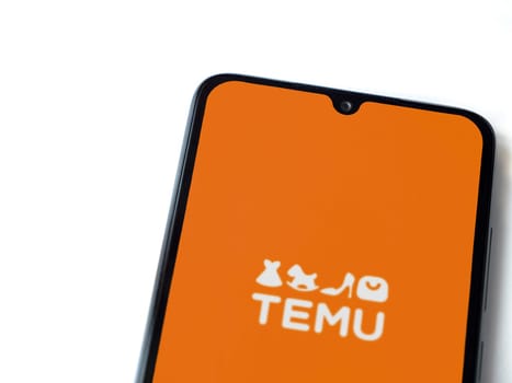Lod, Israel - July 16,2023: Temu app launch screen on smartphone on white background. Top view flat lay with copy space.