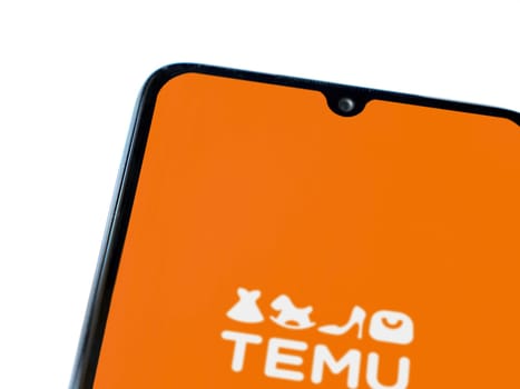 Lod, Israel - July 16,2023: Temu app launch screen on smartphone on white background. Top view flat lay with copy space.
