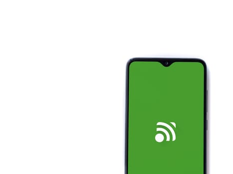 Lod, Israel - July 16,2023: Unified Remote app launch screen on smartphone on white background. Top view flat lay with copy space.