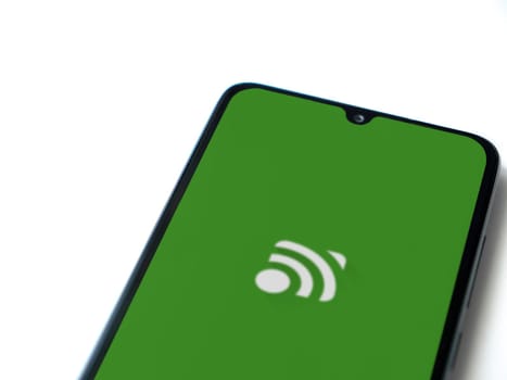 Lod, Israel - July 16,2023: Unified Remote app launch screen on smartphone on white background. Top view flat lay with copy space.