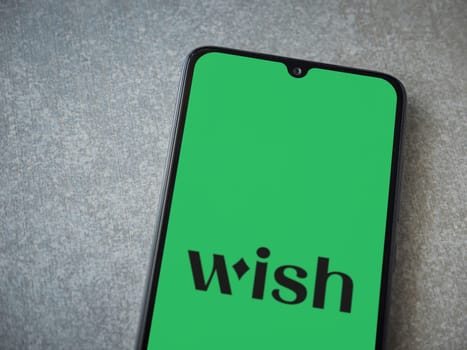 Lod, Israel - July 16,2023: Wish app launch screen on smartphone on ceramic stone background. Top view flat lay with copy space.