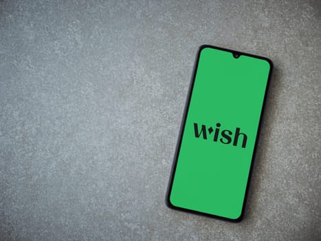 Lod, Israel - July 16,2023: Wish app launch screen on smartphone on ceramic stone background. Top view flat lay with copy space.