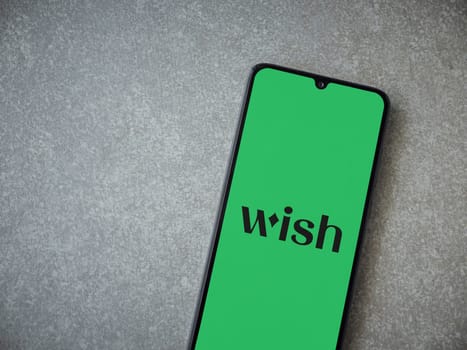 Lod, Israel - July 16,2023: Wish app launch screen on smartphone on ceramic stone background. Top view flat lay with copy space.