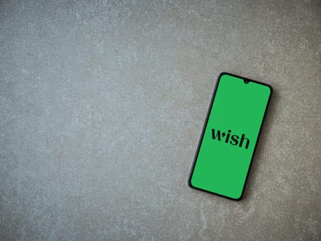 Lod, Israel - July 16,2023: Wish app launch screen on smartphone on ceramic stone background. Top view flat lay with copy space.