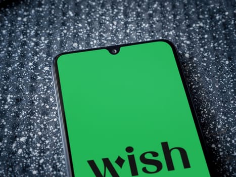 Lod, Israel - July 16,2023: Wish app launch screen on smartphone on metallic background. Close up top view flat lay.