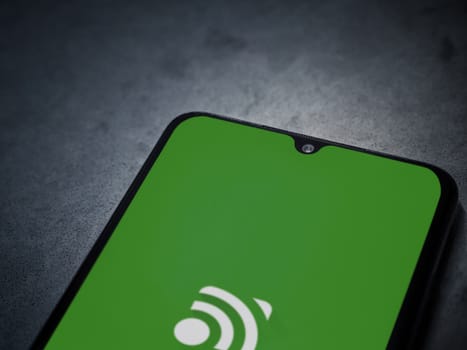 Lod, Israel - July 16,2023: Unified Remote app launch screen on smartphone on dark marble stone background. Top view flat lay with copy space.