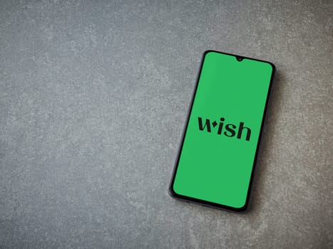 Lod, Israel - July 16,2023: Wish app launch screen on smartphone on ceramic stone background. Top view flat lay with copy space.