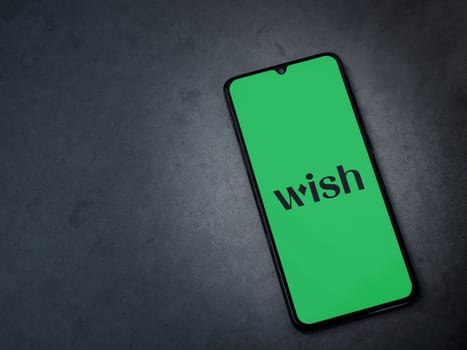 Lod, Israel - July 16,2023: Wish app launch screen on smartphone on dark marble stone background. Top view flat lay with copy space.