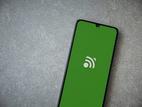 Lod, Israel - July 16,2023: Unified Remote app launch screen on smartphone on ceramic stone background. Top view flat lay with copy space.