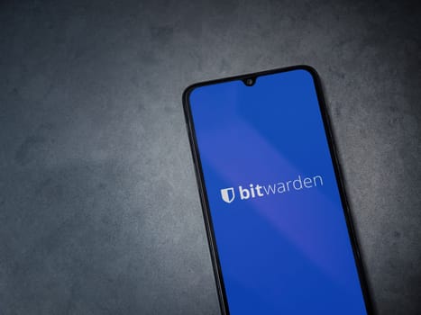 Lod, Israel - July 16,2023: Bitwarden Password Manager app launch screen on smartphone on dark marble stone background. Top view flat lay with copy space.