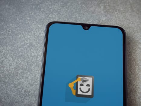 Lod, Israel - July 16,2023: Automate app launch screen on smartphone on ceramic stone background. Top view flat lay with copy space.