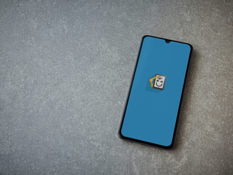 Lod, Israel - July 16,2023: Automate app launch screen on smartphone on ceramic stone background. Top view flat lay with copy space.