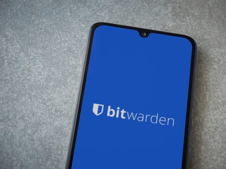 Lod, Israel - July 16,2023: Bitwarden Password Manager app launch screen on smartphone on ceramic stone background. Top view flat lay with copy space.