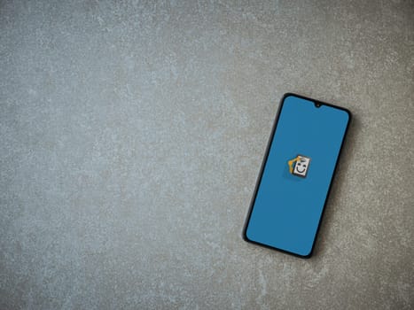 Lod, Israel - July 16,2023: Automate app launch screen on smartphone on ceramic stone background. Top view flat lay with copy space.