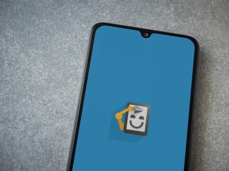 Lod, Israel - July 16,2023: Automate app launch screen on smartphone on ceramic stone background. Top view flat lay with copy space.