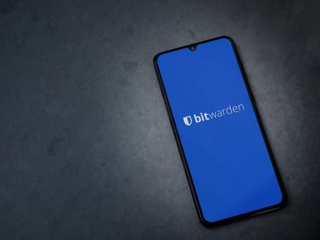 Lod, Israel - July 16,2023: Bitwarden Password Manager app launch screen on smartphone on dark marble stone background. Top view flat lay with copy space.