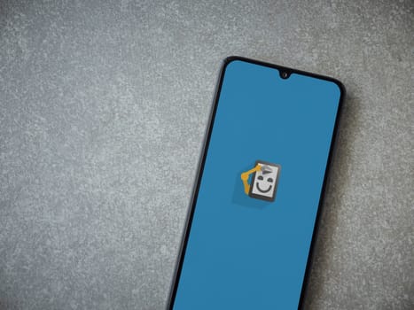 Lod, Israel - July 16,2023: Automate app launch screen on smartphone on ceramic stone background. Top view flat lay with copy space.