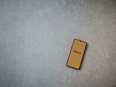 Lod, Israel - July 16,2023: Sonos app launch screen on smartphone on ceramic stone background. Top view flat lay with copy space.