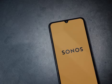 Lod, Israel - July 16,2023: Sonos app launch screen on smartphone on dark marble stone background. Top view flat lay with copy space.