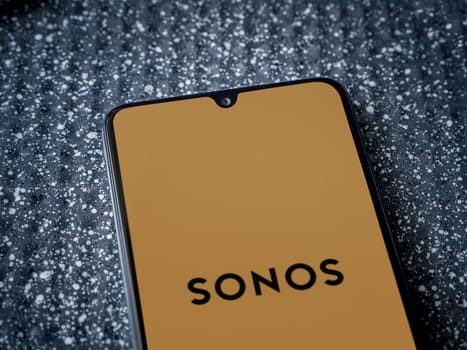 Lod, Israel - July 16,2023: Sonos app launch screen on smartphone on metallic background. Close up top view flat lay.