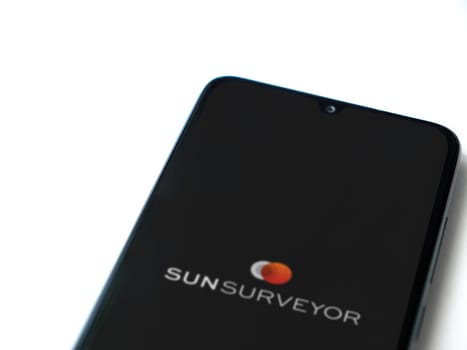 Lod, Israel - July 16,2023: Sun Surveyor app launch screen on smartphone on white background. Top view flat lay with copy space.