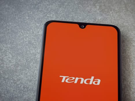 Lod, Israel - July 16,2023: Tenda Wifi app launch screen on smartphone on ceramic stone background. Top view flat lay with copy space.
