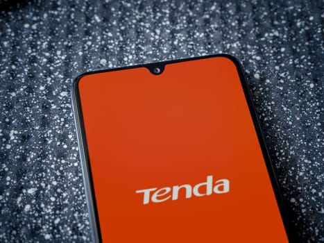 Lod, Israel - July 16,2023: Tenda Wifi app launch screen on smartphone on metallic background. Close up top view flat lay.