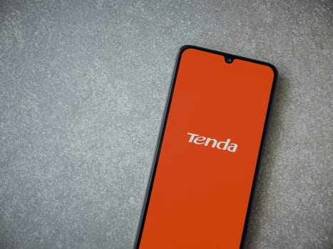 Lod, Israel - July 16,2023: Tenda Wifi app launch screen on smartphone on ceramic stone background. Top view flat lay with copy space.