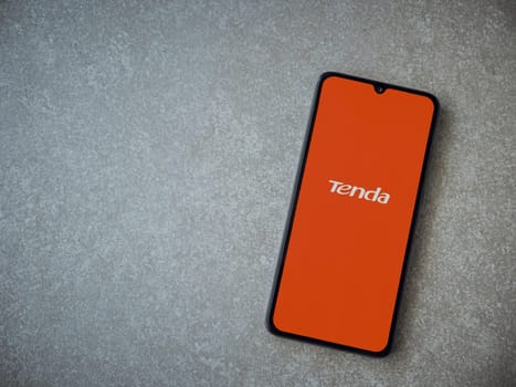 Lod, Israel - July 16,2023: Tenda Wifi app launch screen on smartphone on ceramic stone background. Top view flat lay with copy space.